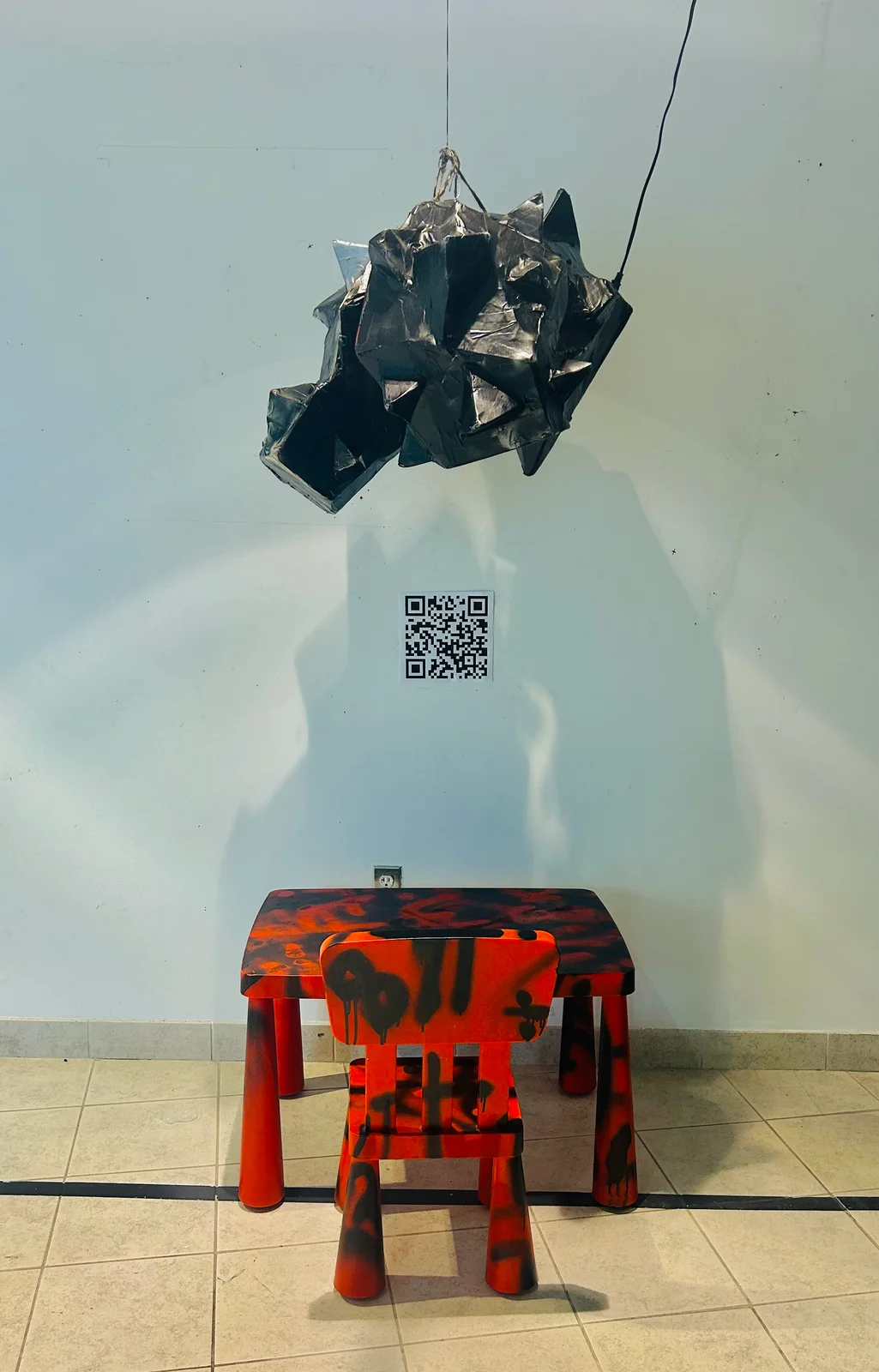 Exhibition of suspended sculpture and a red chair